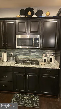 a kitchen with stainless steel appliances a stove a microwave a sink and cabinets