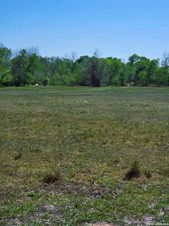 a view of a field with trees in background