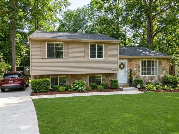 a front view of a house with a garden and plants