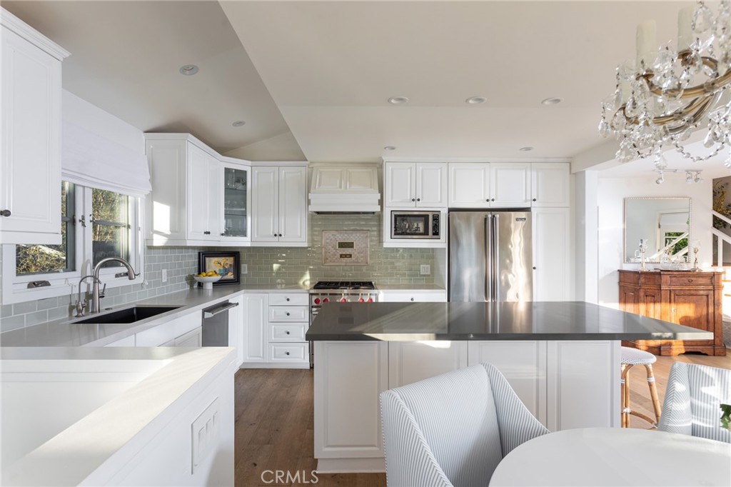 865 Fen Way Laguna Beach, CA 92651 - Photo 4 of 27 a kitchen with stainless steel appliances granite countertop a refrigerator a stove a sink dishwasher and white cabinets with wooden floor
