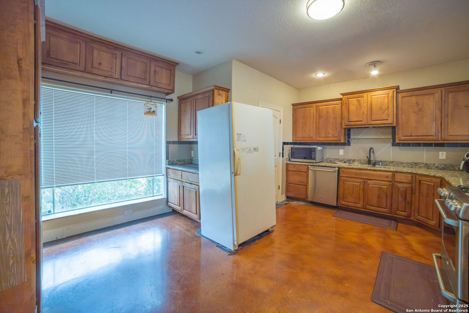 12219 Course View Drive San Antonio, TX 78221 - Photo 3 of 29 a kitchen with a refrigerator a sink and a stove top oven