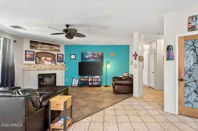 a living room with furniture a flat screen tv and a fireplace
