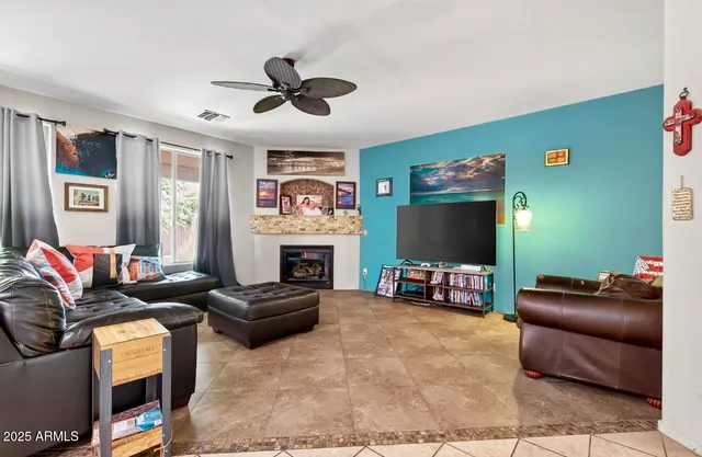 a living room with furniture a fireplace and a flat screen tv