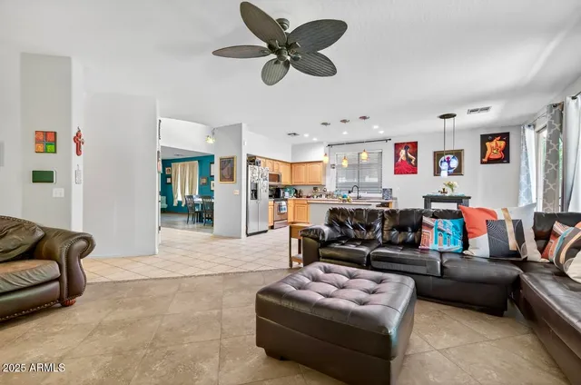 a living room with furniture and a ceiling fan