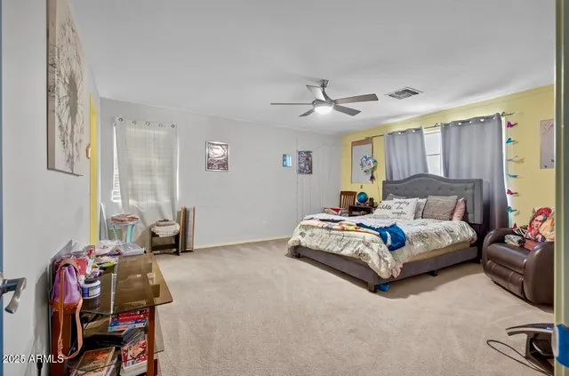 a spacious bedroom with a bed a couch and a window