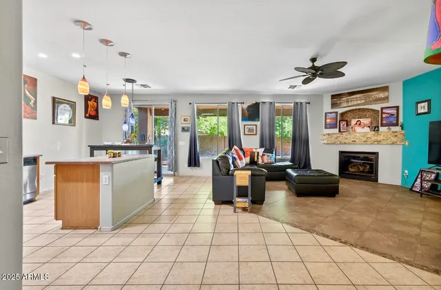 a living room with furniture a fireplace and a kitchen view