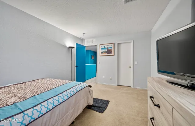 a bedroom with a bed and a flat screen tv