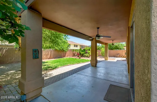 a view of a patio with a table and chairs under an umbrella