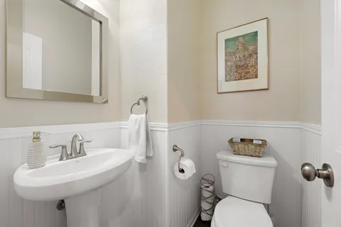 a bathroom with a toilet sink and mirror