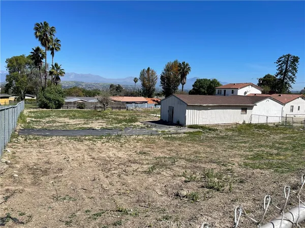 a view of a house with a yard and mountain view in the background