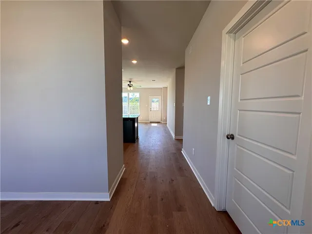a view of a hallway with wooden floor