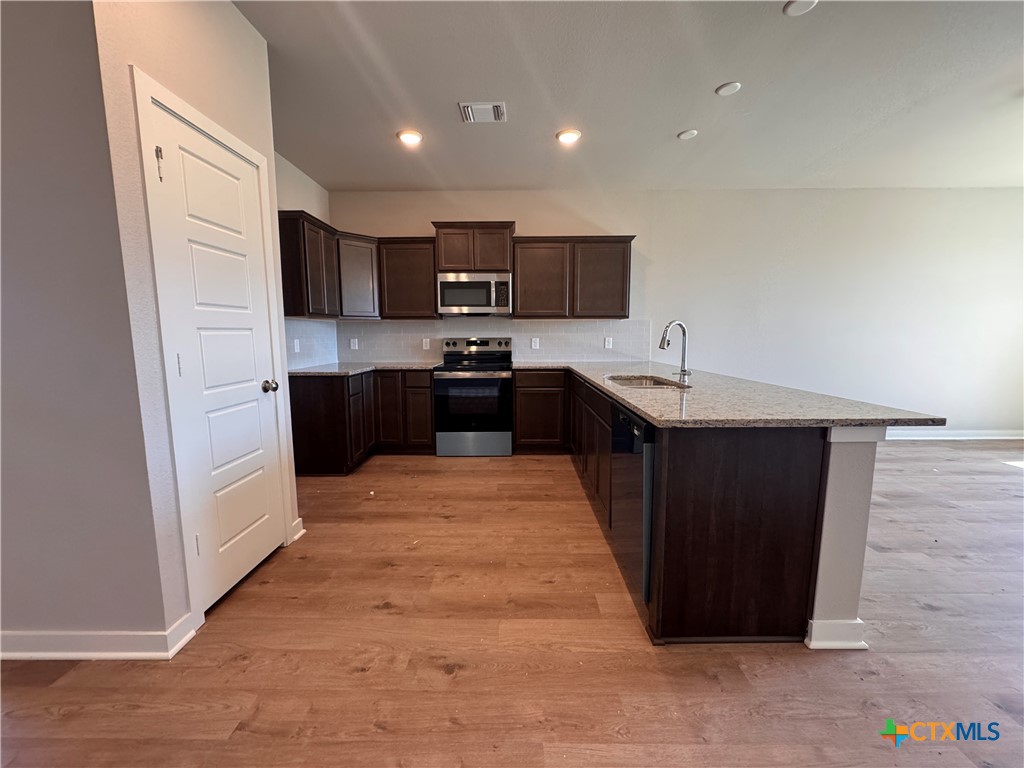 409 University Avenue Troy, TX 76579 - Photo 6 of 20 a large kitchen with stainless steel appliances kitchen island granite countertop a refrigerator and a stove top oven