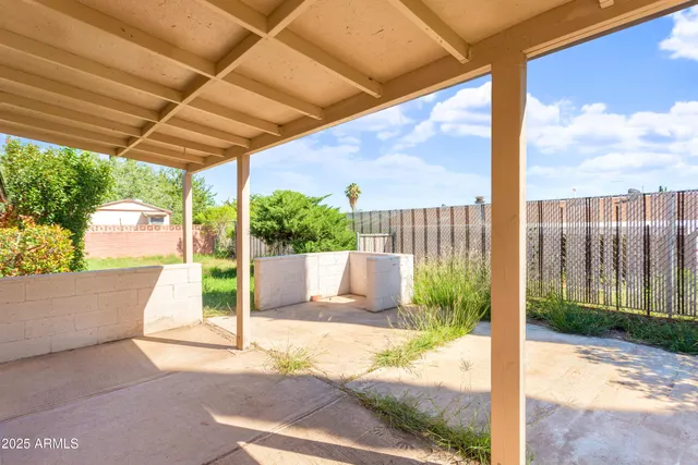 a view of a patio with a table and chairs and floor to ceiling window