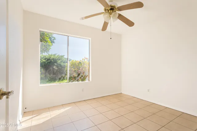 an empty room with a window and a fan