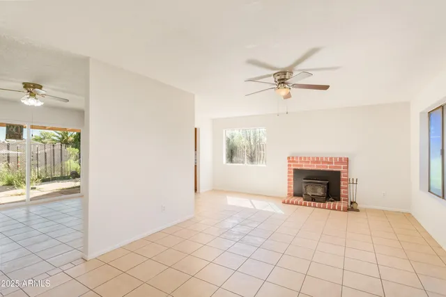 an empty room with fireplace and windows