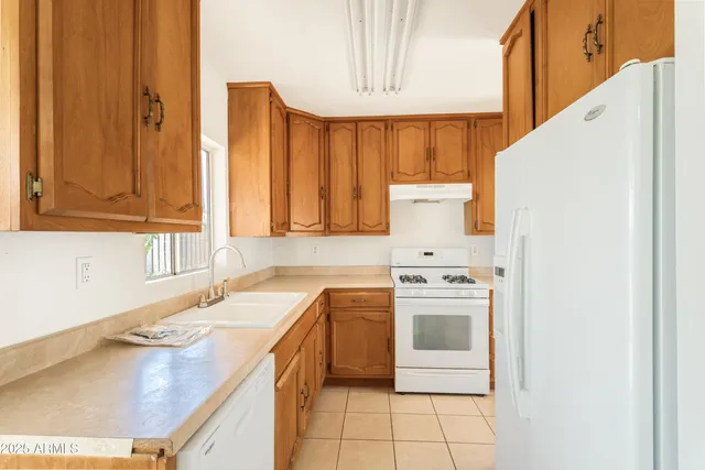 a kitchen with a sink a stove and cabinets