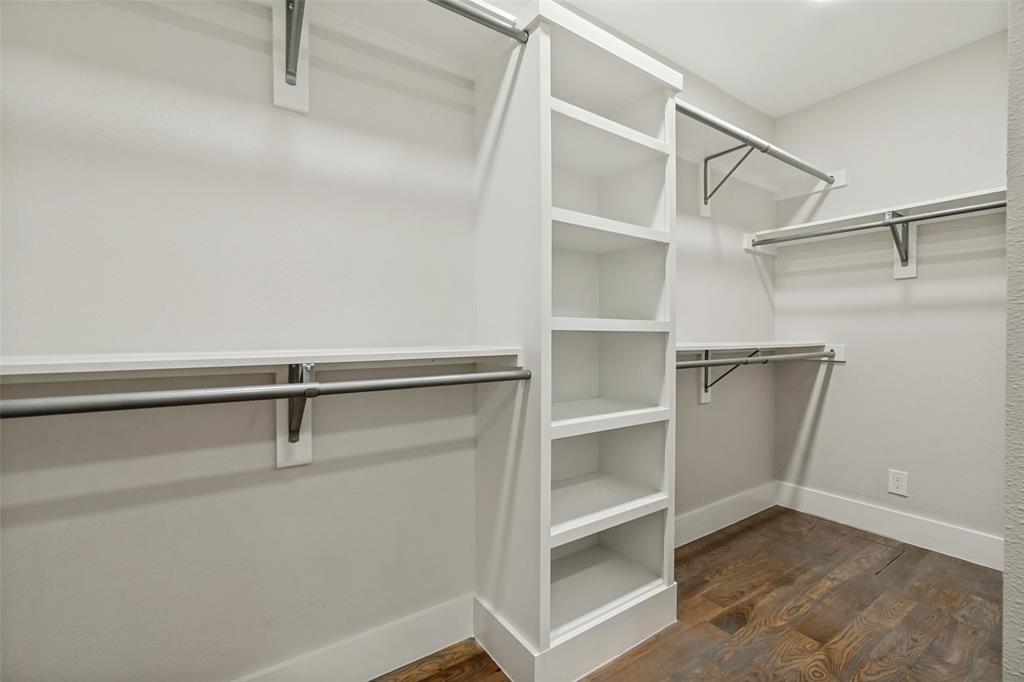 2006 Marydale Road Dallas, TX 75208 - Photo 28 of 40 Walk-in closet featuring built-in shelving, multiple hanging rods, and wood-finish flooring