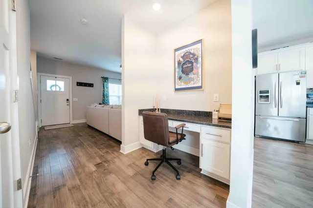 a workspace with wooden floor and a kitchen
