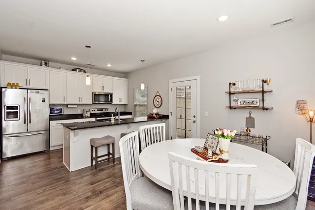 a kitchen with stainless steel appliances kitchen island granite countertop a kitchen island hardwood floor and a sink