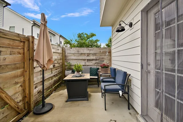 a balcony with chairs and a potted plant