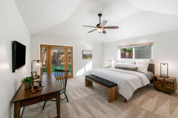 a spacious bedroom with a bed and a flat screen tv
