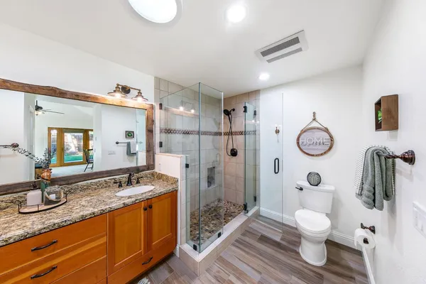 a bathroom with a granite countertop toilet sink and shower