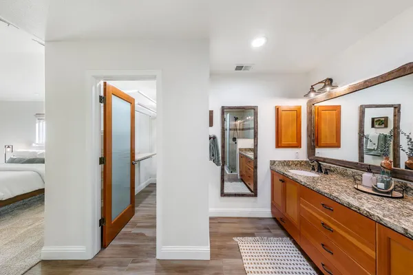 a bathroom with a granite countertop sink and a mirror