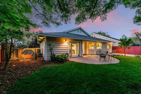 a backyard of a house with table and chairs