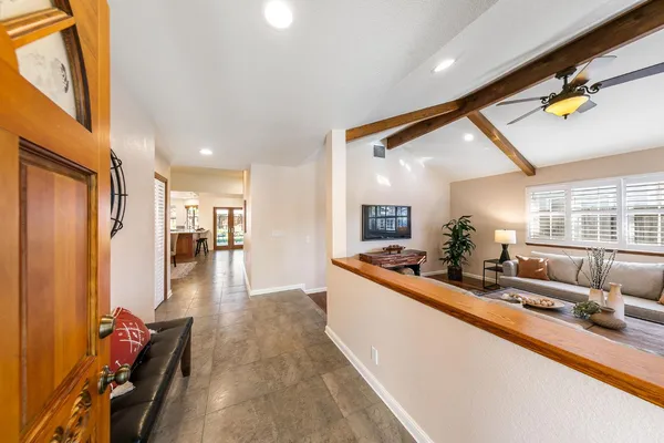 a large living room with stainless steel appliances a couch and a view of kitchen