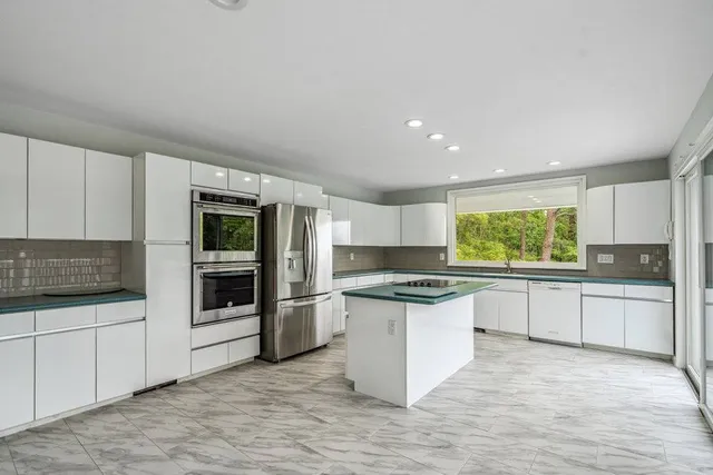 a kitchen with stainless steel appliances granite countertop a sink stove and refrigerator