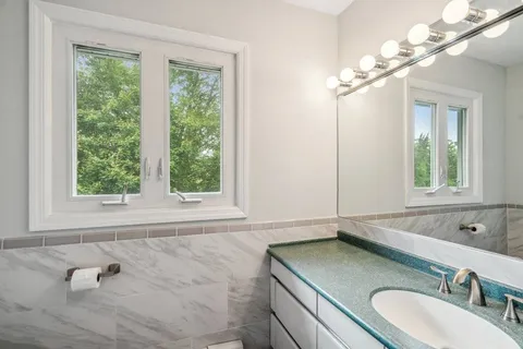 an aerial view of residential houses with outdoor space and trees