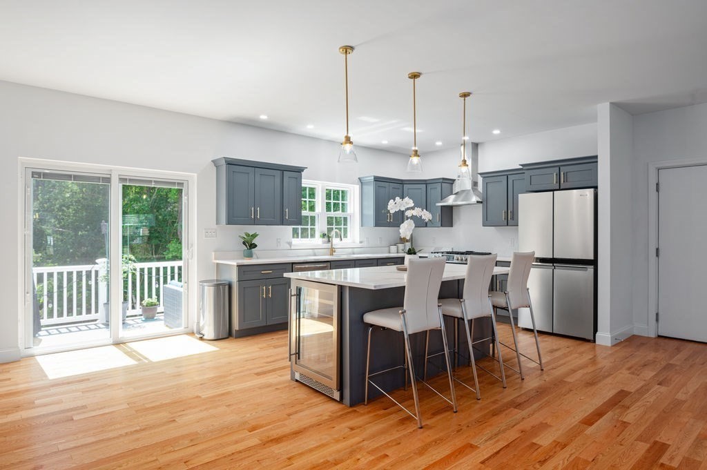 a kitchen with stainless steel appliances kitchen island granite countertop a dining table chairs and granite counter tops