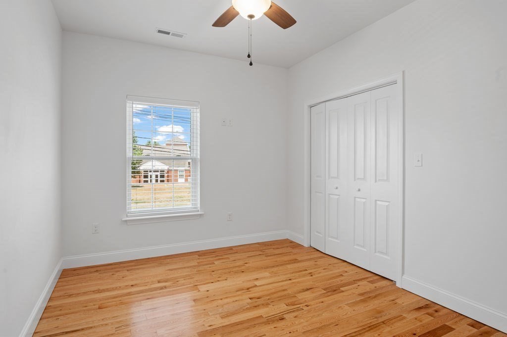 196 Main Street, Unit 196 Groveland, MA 01834 - Photo 19 of 35 a view of an empty room with wooden floor and a window