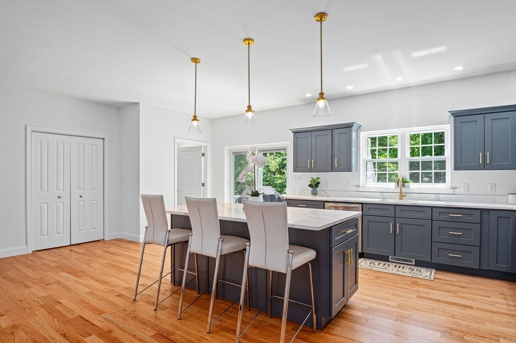 196 Main Street, Unit 196 Groveland, MA 01834 - Photo 2 of 35 a kitchen with a dining table chairs sink and cabinets
