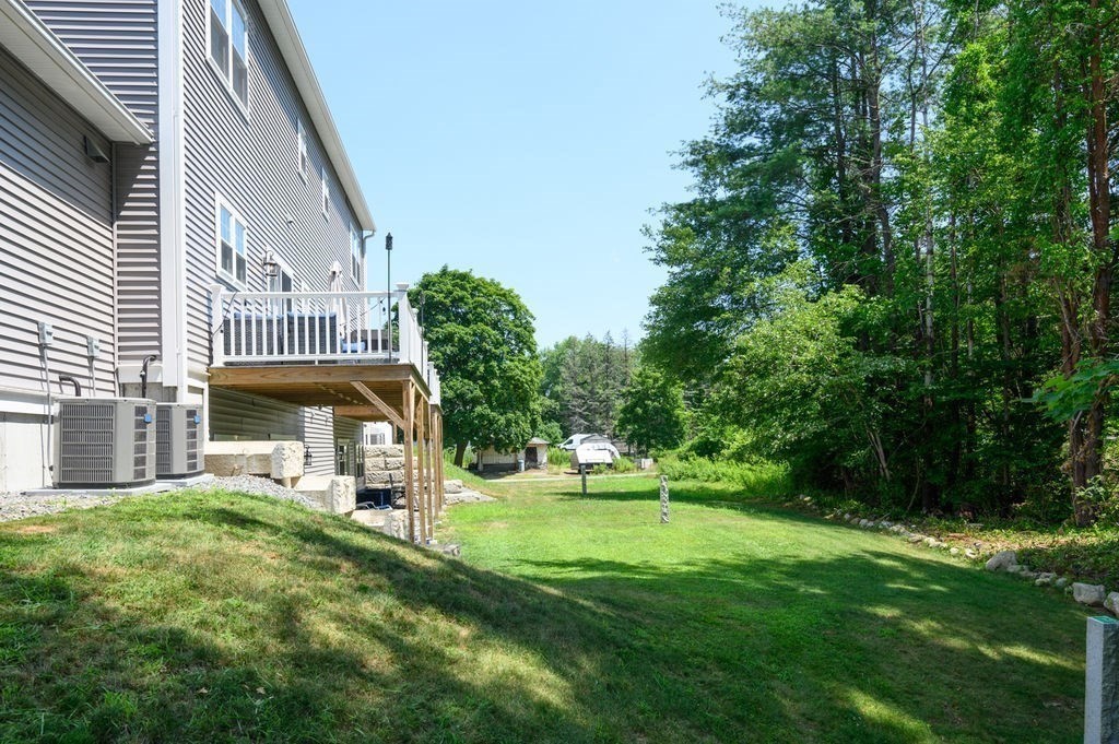 196 Main Street, Unit 196 Groveland, MA 01834 - Photo 31 of 35 a front view of a house with a yard table and chairs