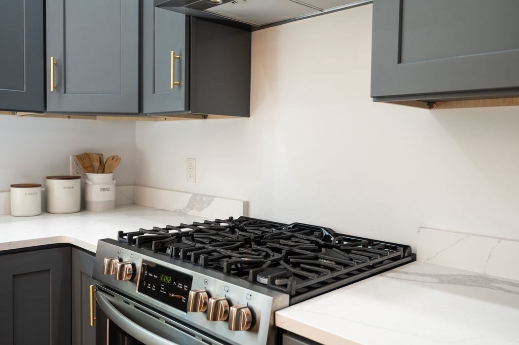 196 Main Street, Unit 196 Groveland, MA 01834 - Photo 4 of 35 a kitchen with granite countertop a stove and a cabinets