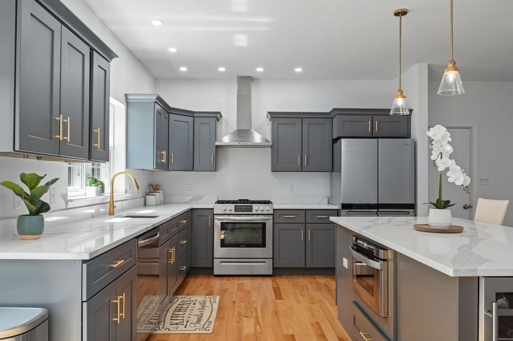 196 Main Street, Unit 196 Groveland, MA 01834 - Photo 6 of 35 a kitchen with a sink stainless steel appliances and wooden cabinets