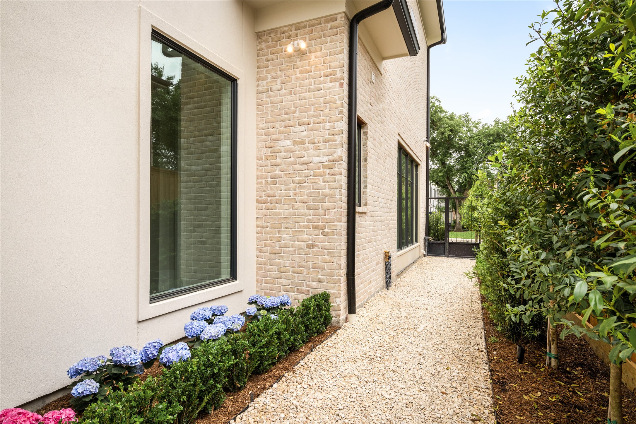 4006 Overbrook Lane Houston, TX 77027 - Photo 46 of 50 Fully landscaped side yard with gravel pathway, lush greenery, and gated access.