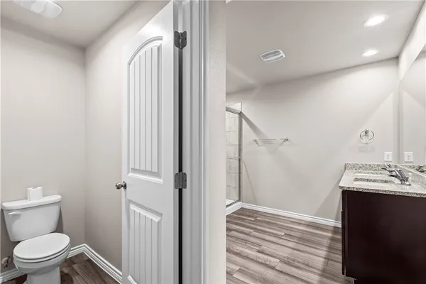 a bathroom with a sink a toilet a mirror and shower