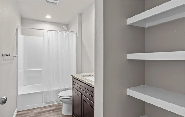 a bathroom with a sink a toilet and shower