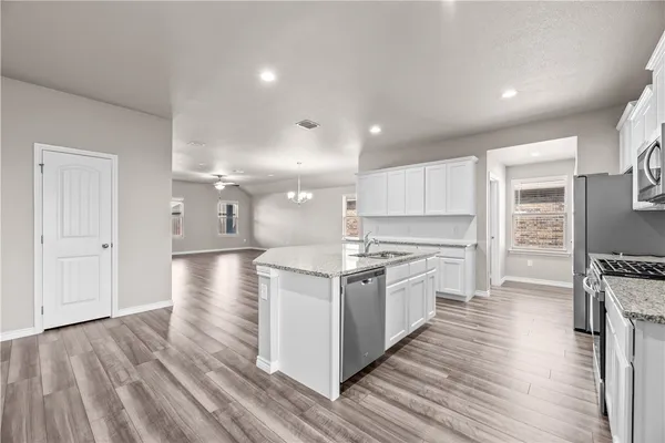 a kitchen with stainless steel appliances granite countertop a stove and a refrigerator