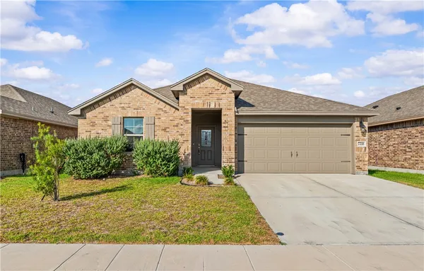 a front view of a house with yard and tress