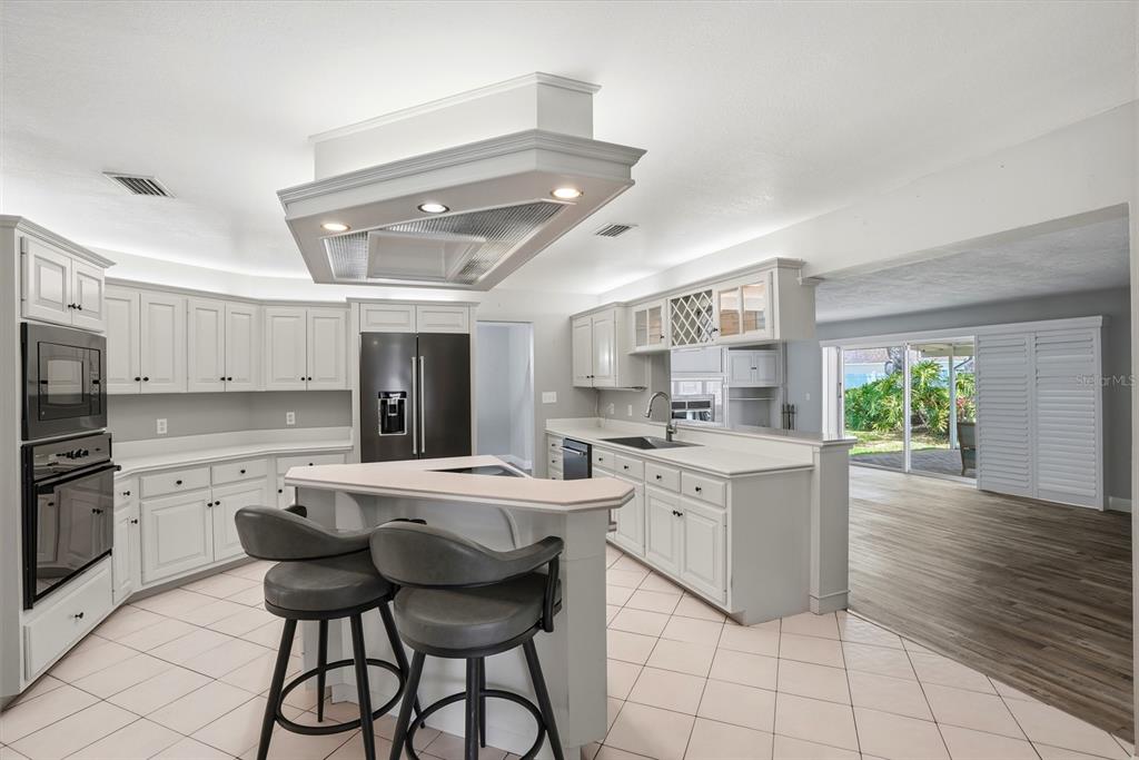 9760 136th Street Seminole, FL 33776 - Photo 14 of 41 a kitchen with stainless steel appliances kitchen island granite countertop a sink and cabinets
