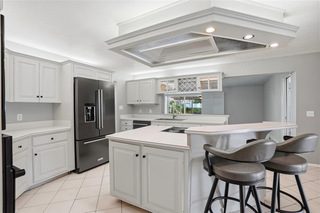 9760 136th Street Seminole, FL 33776 - Photo 15 of 41 a kitchen with a refrigerator and white cabinets
