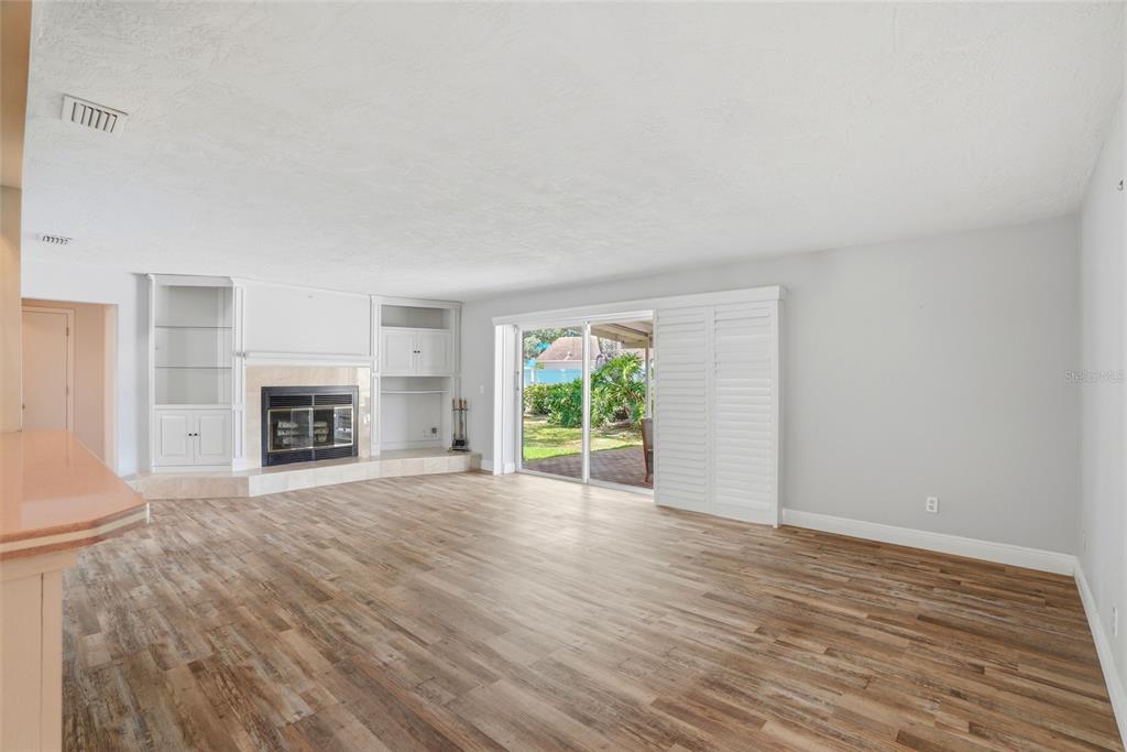 9760 136th Street Seminole, FL 33776 - Photo 18 of 41 wooden floor fireplace and windows in an empty room