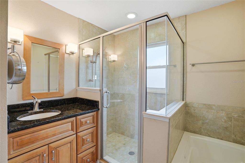 9760 136th Street Seminole, FL 33776 - Photo 21 of 41 a bathroom with a granite countertop sink a mirror and shower