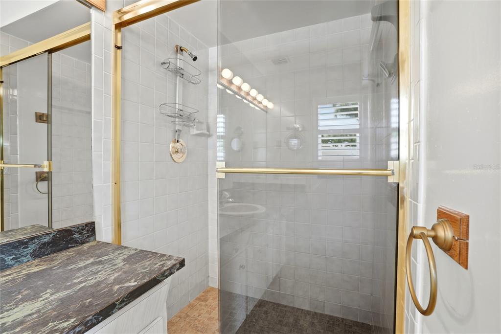 9760 136th Street Seminole, FL 33776 - Photo 29 of 41 a bathroom with a granite countertop shower and a sink