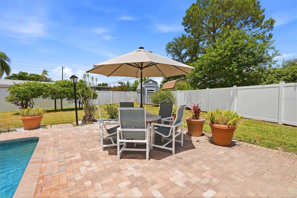 9760 136th Street Seminole, FL 33776 - Photo 33 of 41 a view of a patio with a table and chairs under an umbrella