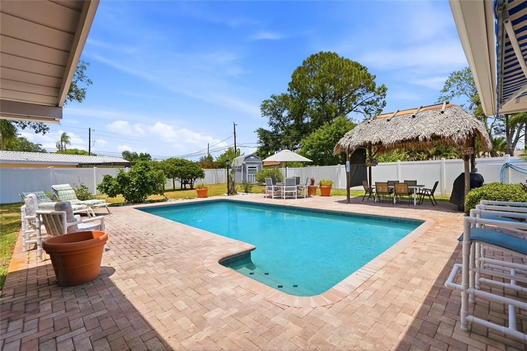 9760 136th Street Seminole, FL 33776 - Photo 4 of 41 a view of a swimming pool with outdoor seating