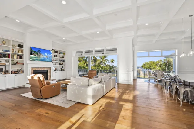 a large kitchen with kitchen island a sink a stove a dining table and chairs with wooden floor